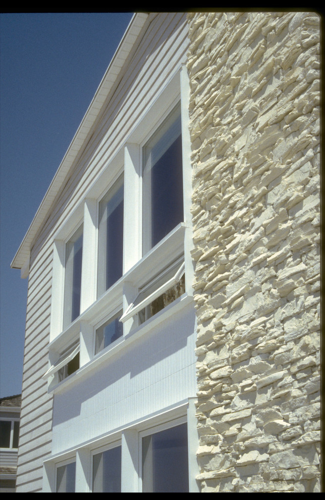Immagine della facciata di una casa grande bianca stile marinaro a due piani con rivestimenti misti