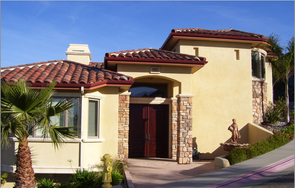 Mittelgroßes Mediterranes Haus mit gelber Fassadenfarbe und Putzfassade in San Luis Obispo