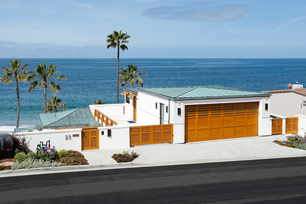 На фото: большой, белый частный загородный дом в морском стиле с разными уровнями, облицовкой из цементной штукатурки и металлической крышей