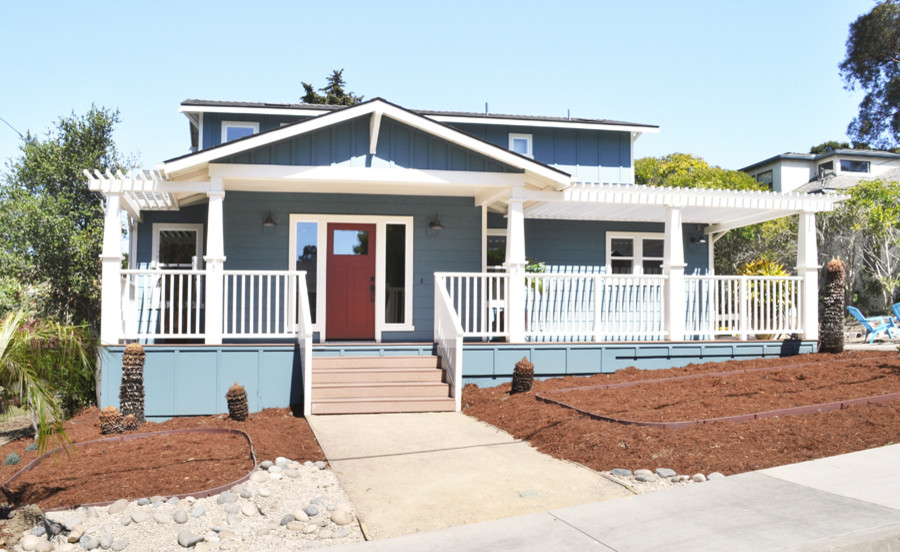 Imagen de fachada de casa azul de estilo americano de tamaño medio de dos plantas con revestimiento de aglomerado de cemento, tejado a dos aguas y tejado de teja de madera