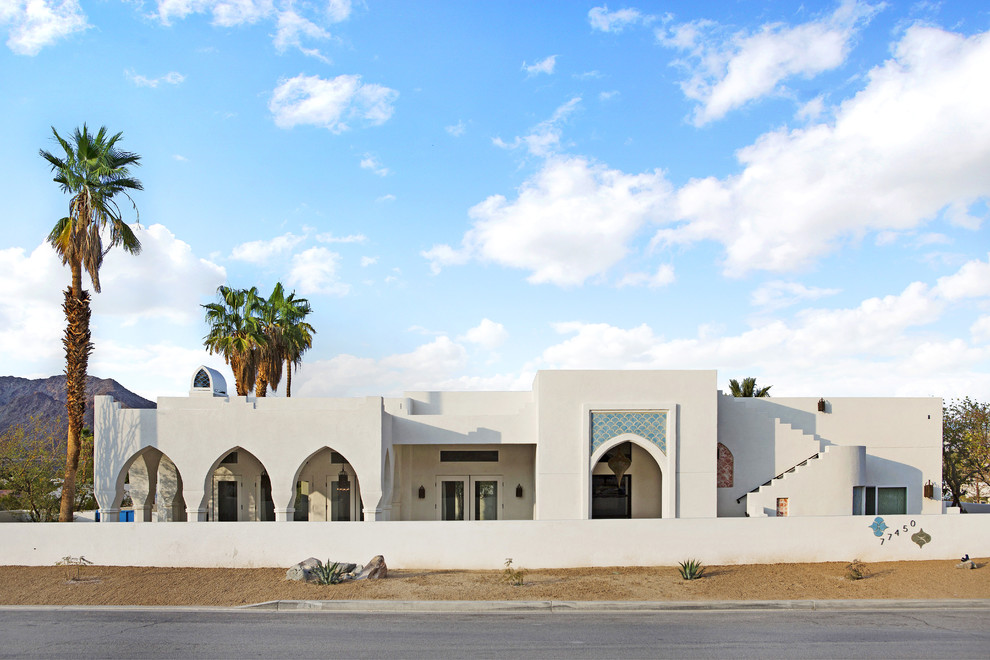 Foto de fachada de casa blanca mediterránea de una planta con revestimiento de estuco y tejado plano