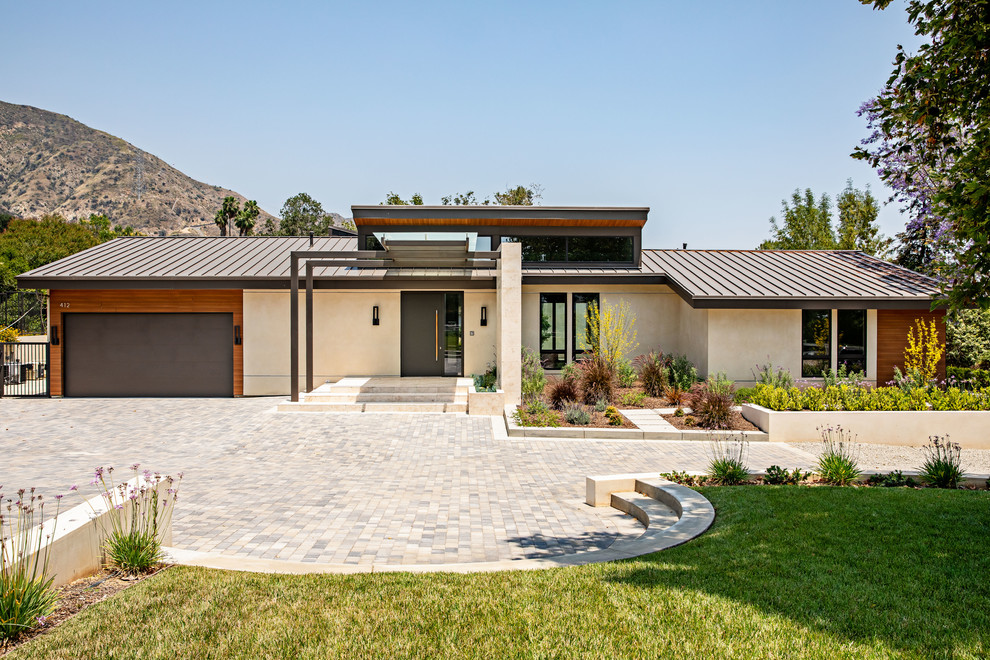 Idee per la facciata di una casa beige moderna a un piano di medie dimensioni con rivestimento in stucco e copertura in metallo o lamiera