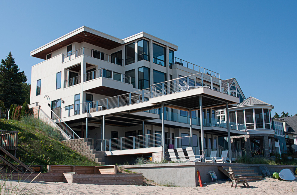 Стильный дизайн: огромный дом в морском стиле с разными уровнями и облицовкой из цементной штукатурки - последний тренд