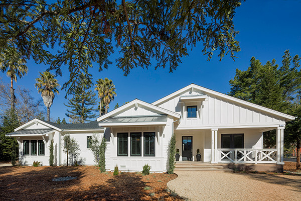 This is an example of a medium sized and white country bungalow house exterior in San Francisco with wood cladding and a pitched roof.