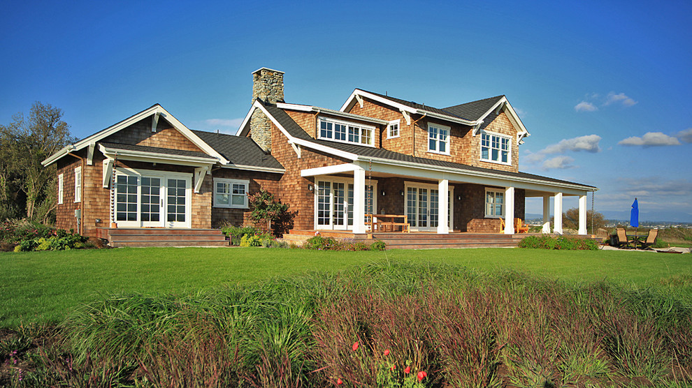 Example of a large mountain style brown two-story wood house exterior design in Seattle with a hip roof and a shingle roof