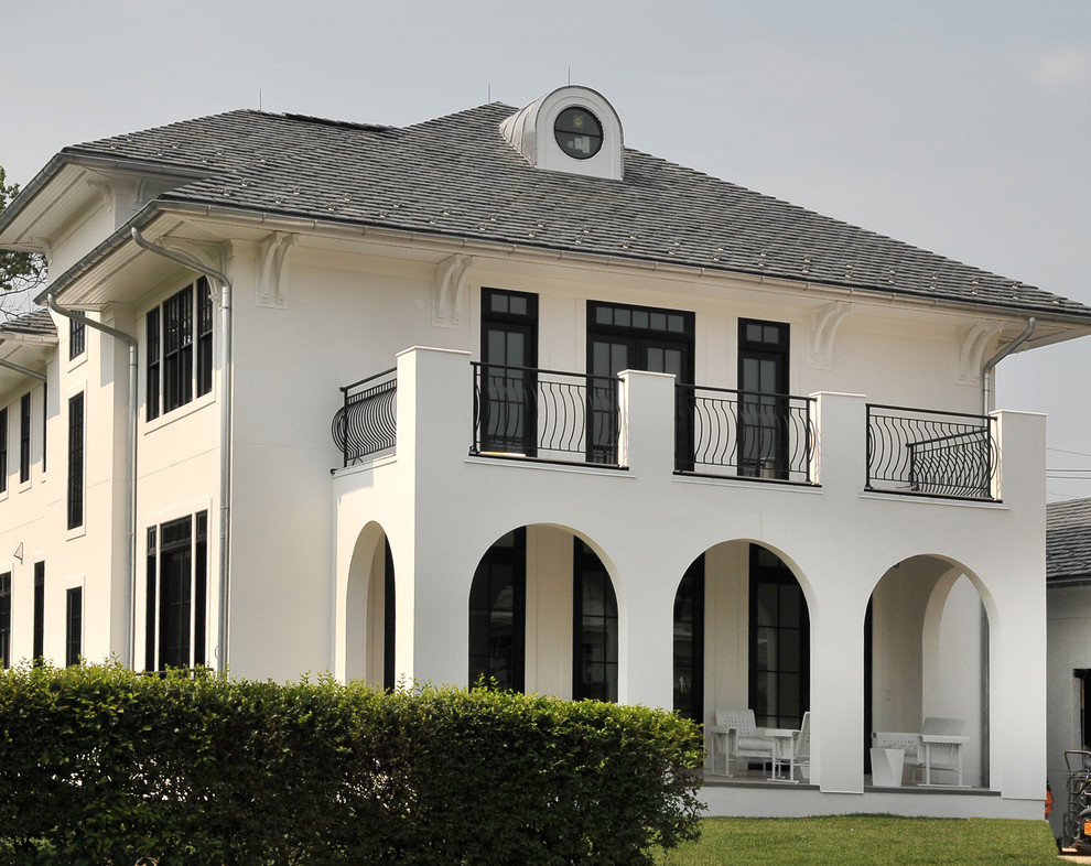 Huge minimalist white three-story stucco house exterior photo in New York with a hip roof and a shingle roof