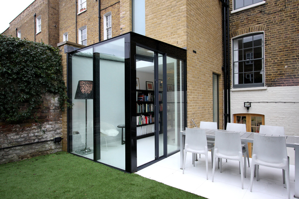 Aménagement d'une petite façade de maison beige moderne en verre de plain-pied.