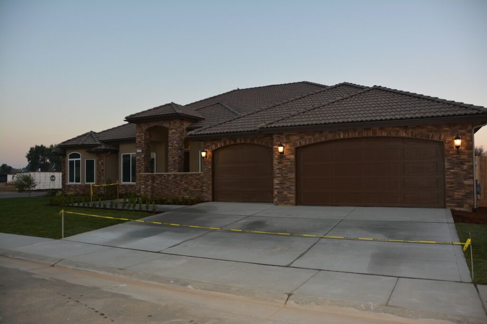 Inspiration for a large and brown modern bungalow house exterior in Other with stone cladding.