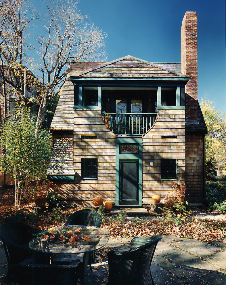 На фото: деревянный, двухэтажный, коричневый дом среднего размера в классическом стиле с вальмовой крышей