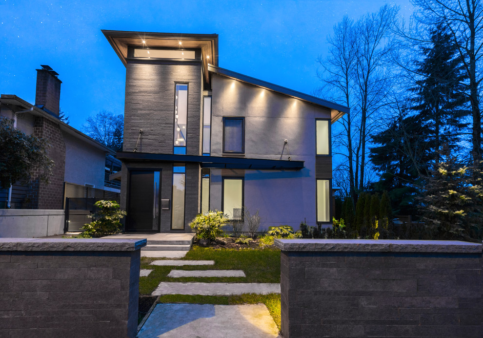 Cette image montre une façade de maison grise minimaliste de taille moyenne et à deux étages et plus avec un revêtement mixte et un toit en appentis.