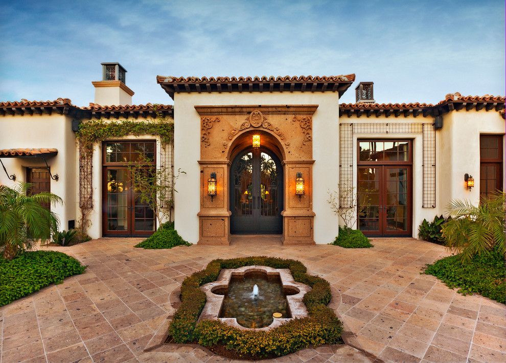 Inspiration for a mediterranean beige one-story stucco exterior home remodel in Phoenix