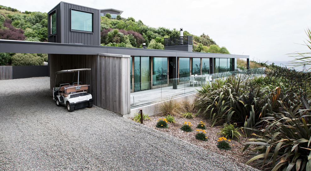 Inspiration pour une façade de maison métallique et noire marine de taille moyenne et à deux étages et plus avec un toit plat.