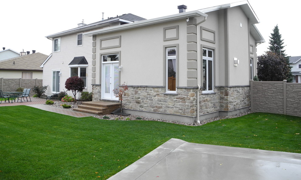Example of a mid-sized classic gray one-story stucco house exterior design in Ottawa with a hip roof and a shingle roof