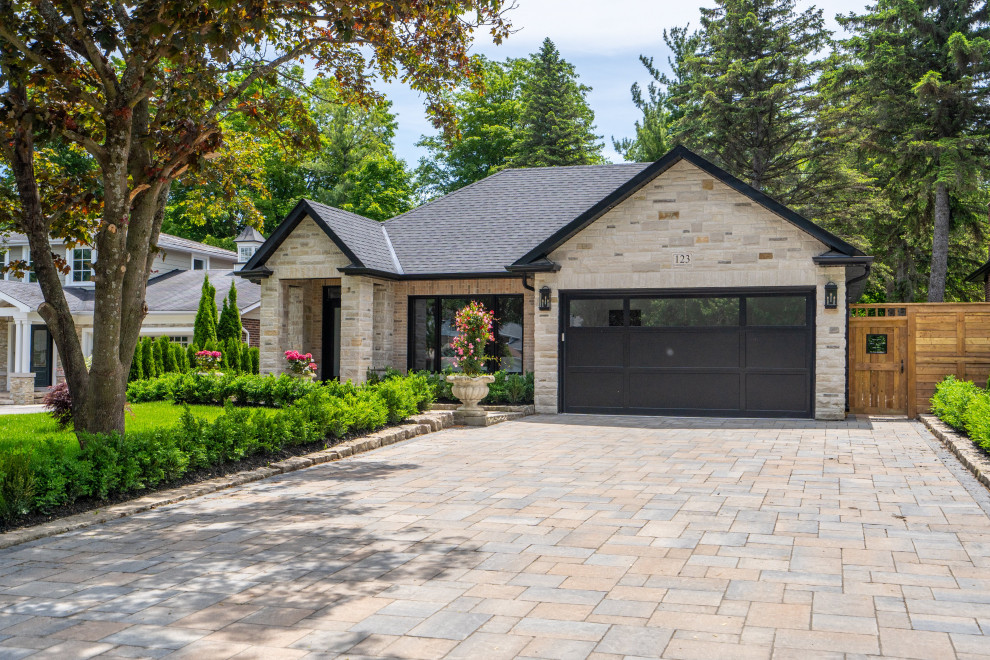 This is an example of a medium sized and white classic split-level detached house in Toronto with stone cladding, a hip roof and a shingle roof.