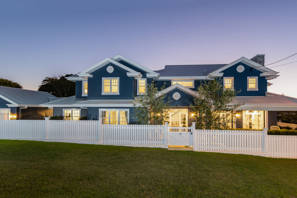 Foto della villa blu stile marinaro a due piani con tetto a capanna, copertura in metallo o lamiera, tetto grigio e pannelli sovrapposti
