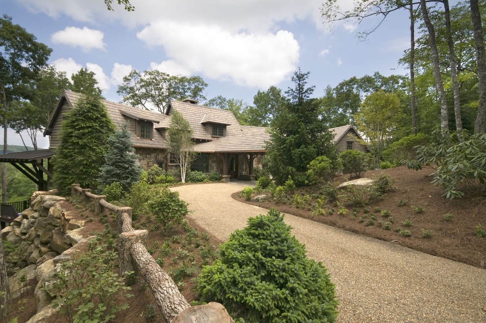 Large mountain style two-story stone exterior home photo in Atlanta