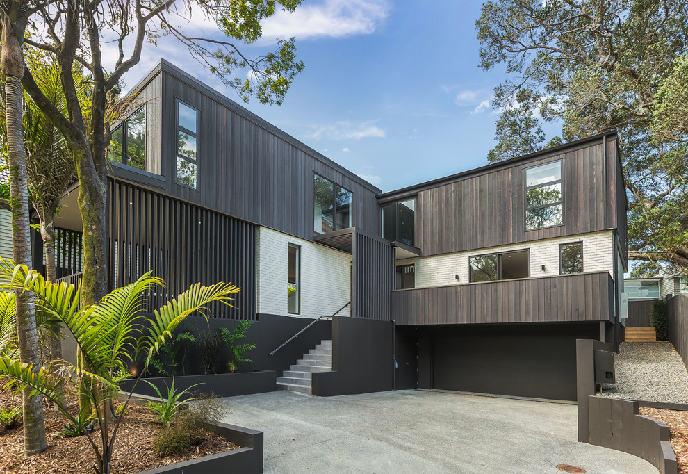 Großes, Dreistöckiges Modernes Einfamilienhaus mit Mix-Fassade, bunter Fassadenfarbe und Pultdach in Auckland