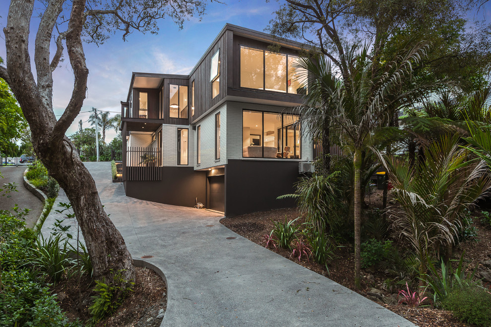 Идея дизайна: двухэтажный, коричневый частный загородный дом в современном стиле с комбинированной облицовкой и плоской крышей