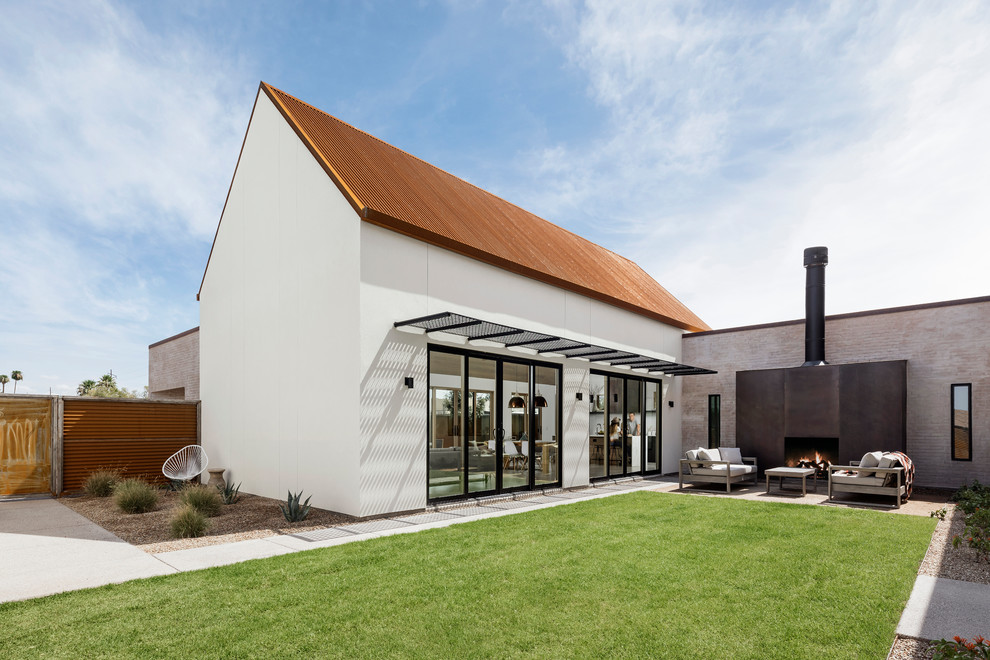 Idée de décoration pour une façade de maison blanche sud-ouest américain en stuc de plain-pied avec un toit à deux pans et un toit en métal.