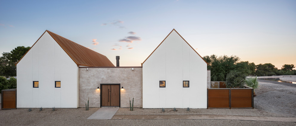 Idées déco pour une façade de maison blanche sud-ouest américain en stuc de plain-pied avec un toit à deux pans et un toit en métal.