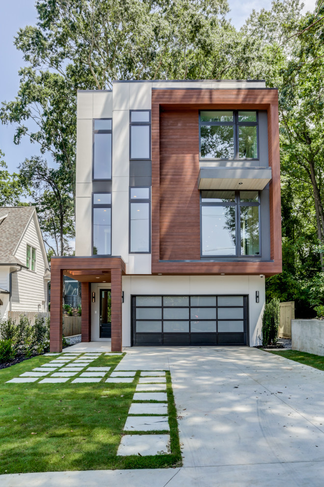 Exemple d'une façade de maison multicolore tendance en panneau de béton fibré à deux étages et plus et de taille moyenne avec un toit plat.