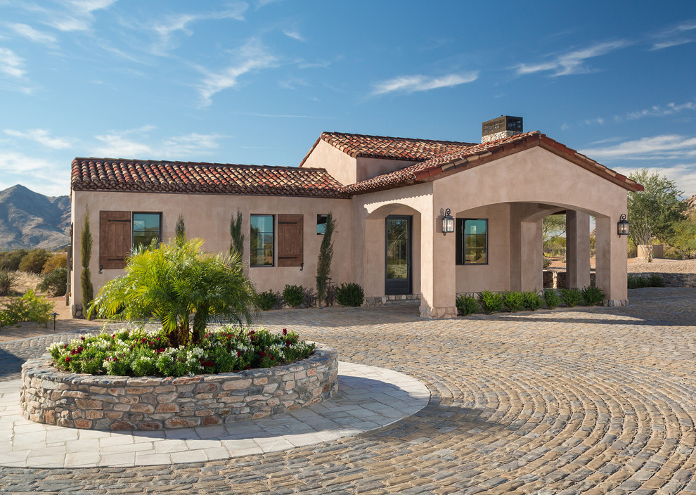 Ispirazione per la villa ampia marrone mediterranea a un piano con rivestimento in stucco, tetto a padiglione e copertura in tegole