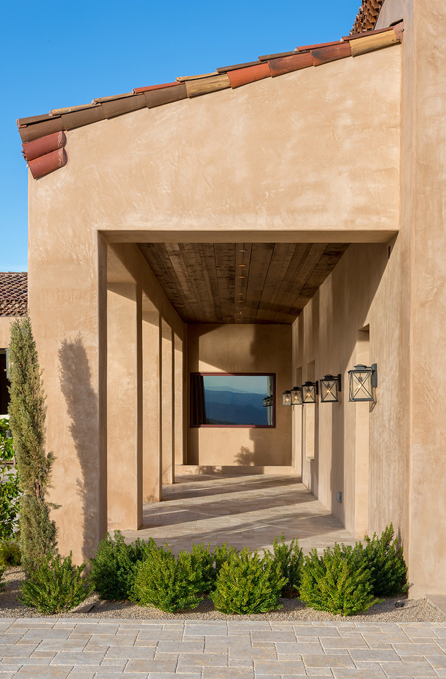 Стильный дизайн: огромный, одноэтажный, коричневый частный загородный дом в средиземноморском стиле с облицовкой из цементной штукатурки, вальмовой крышей и черепичной крышей - последний тренд