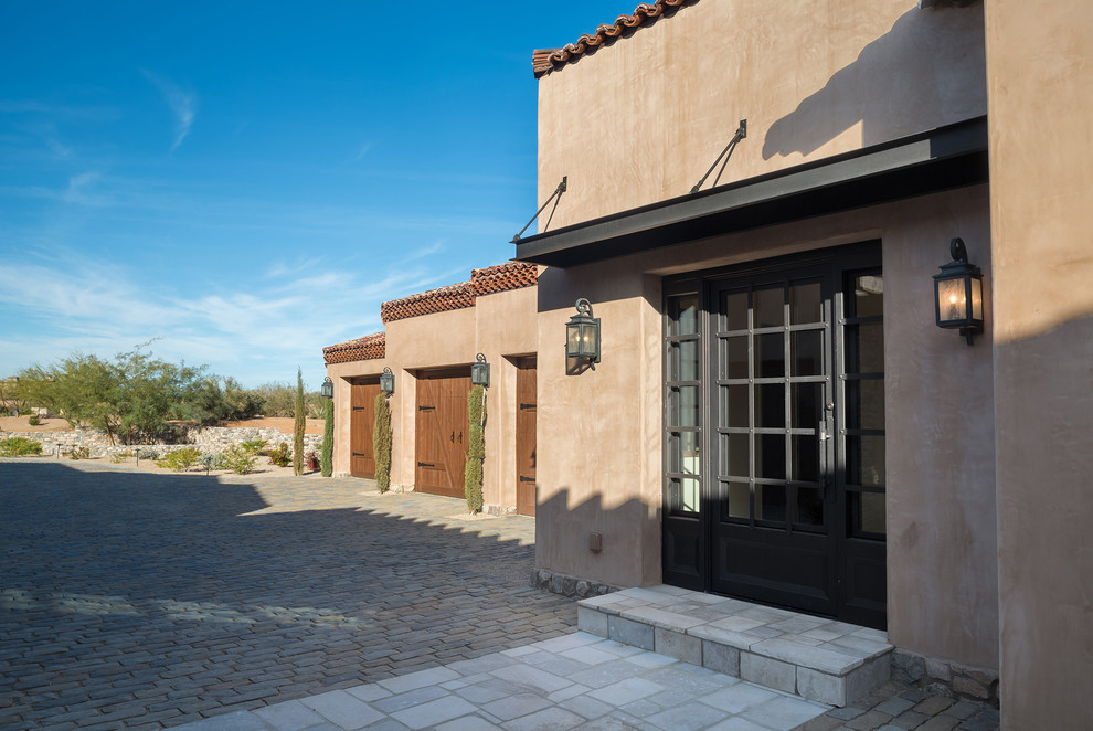 Example of a huge tuscan brown one-story stucco house exterior design in Phoenix with a hip roof and a tile roof