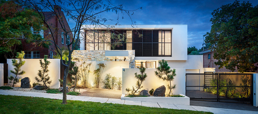 Modelo de fachada blanca minimalista de dos plantas con revestimientos combinados y tejado plano