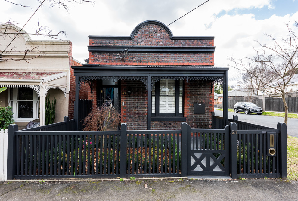 This is an example of a red bohemian bungalow brick detached house in Melbourne.