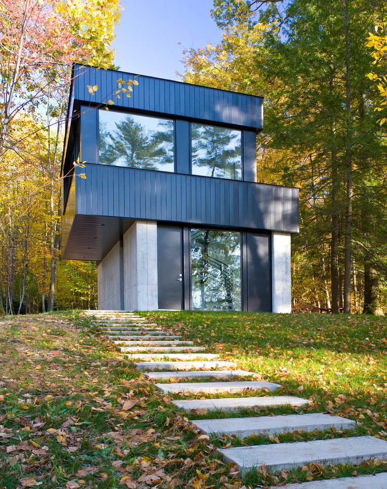 Großes, Zweistöckiges Modernes Einfamilienhaus mit Metallfassade, schwarzer Fassadenfarbe, Flachdach und Blechdach in Burlington