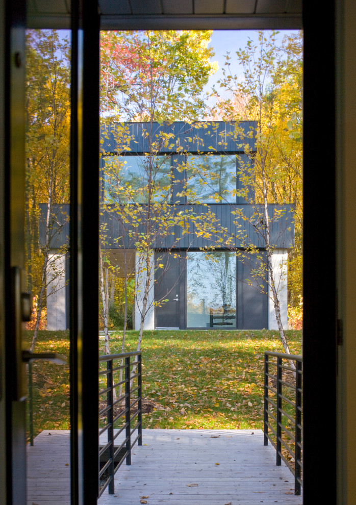 Large contemporary black two-story metal exterior home idea in Burlington with a metal roof