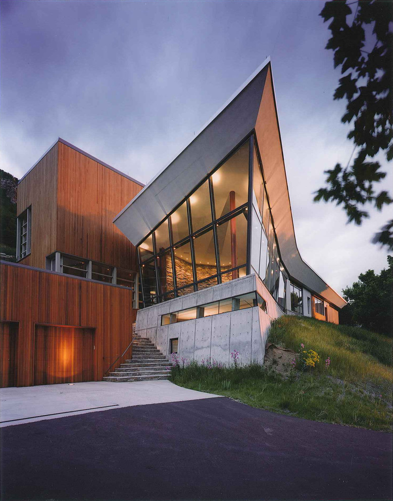 Imagen de fachada marrón contemporánea extra grande de tres plantas con revestimientos combinados y tejado a la holandesa