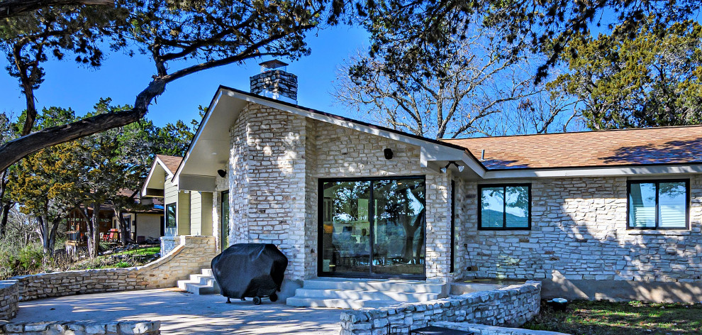 Mittelgroßes, Einstöckiges Mediterranes Einfamilienhaus mit Steinfassade, beiger Fassadenfarbe, Satteldach und Schindeldach in Austin