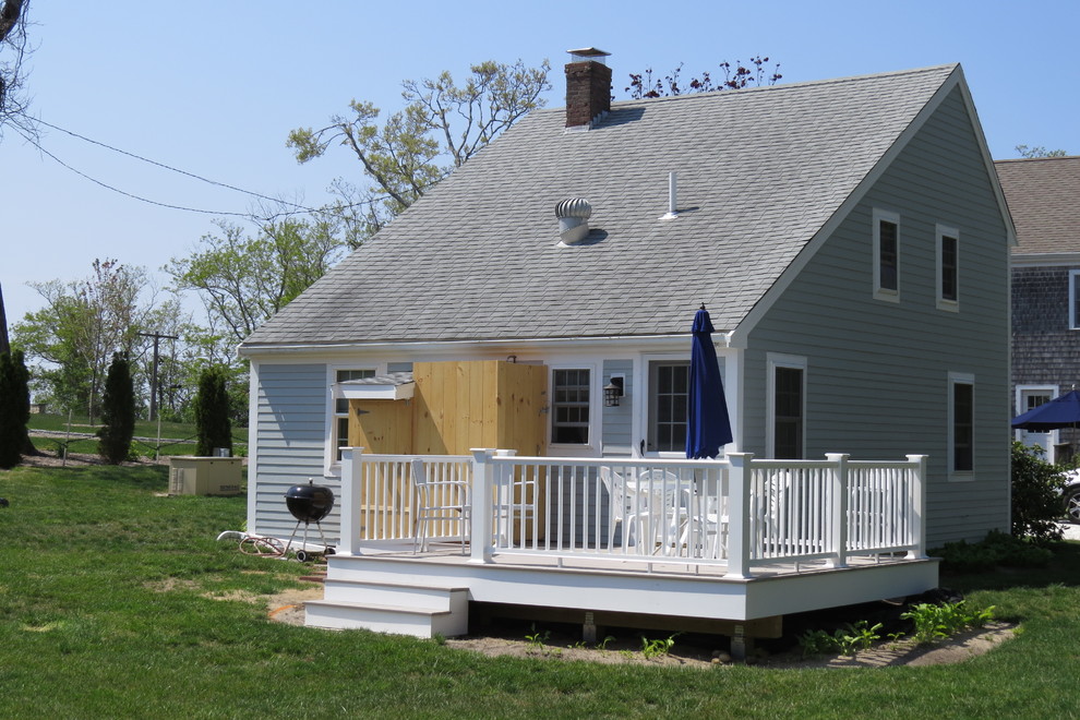 Imagen de fachada de casa gris clásica de tamaño medio de dos plantas con revestimiento de vinilo, tejado a dos aguas y tejado de teja de madera
