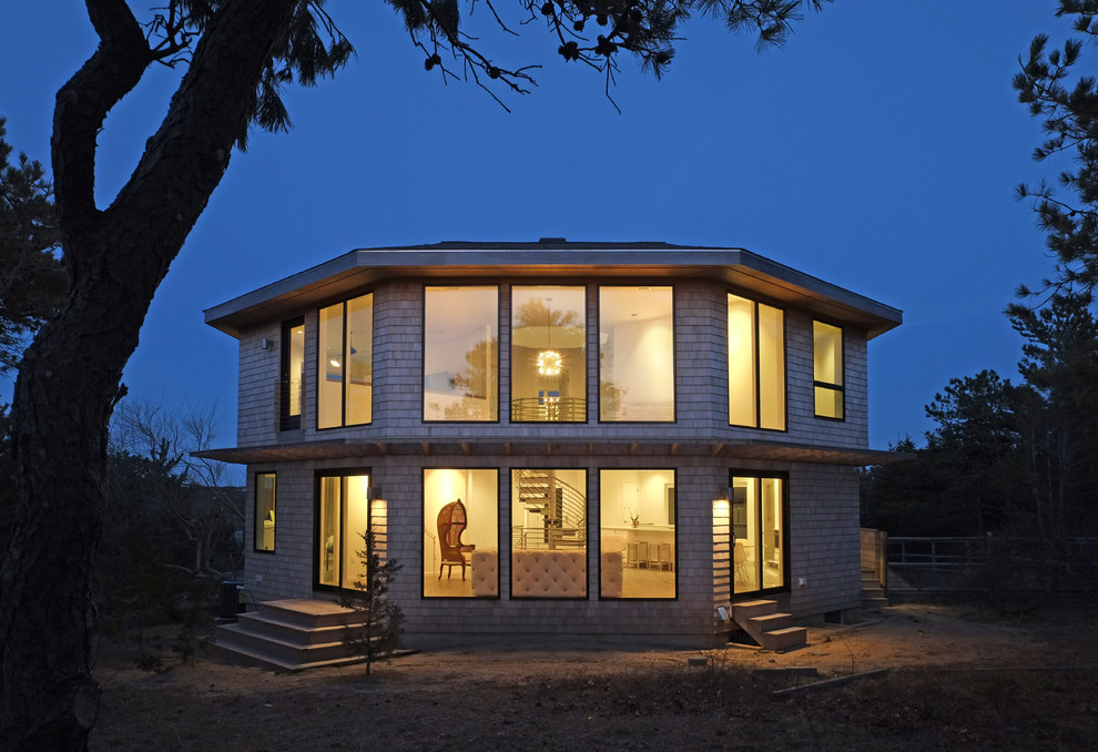 Aménagement d'une grande façade de maison marron contemporaine en bois à un étage avec un toit à quatre pans et un toit en shingle.