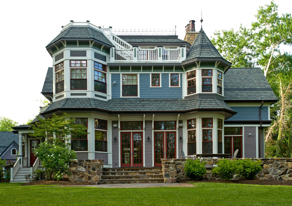 Diseño de fachada azul tradicional grande de dos plantas con revestimiento de madera y tejado a dos aguas