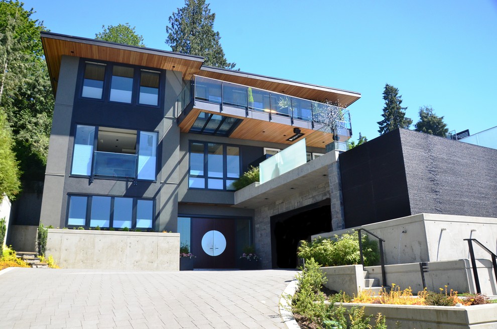 Großes, Dreistöckiges Modernes Einfamilienhaus mit Betonfassade, grauer Fassadenfarbe und Pultdach in Vancouver