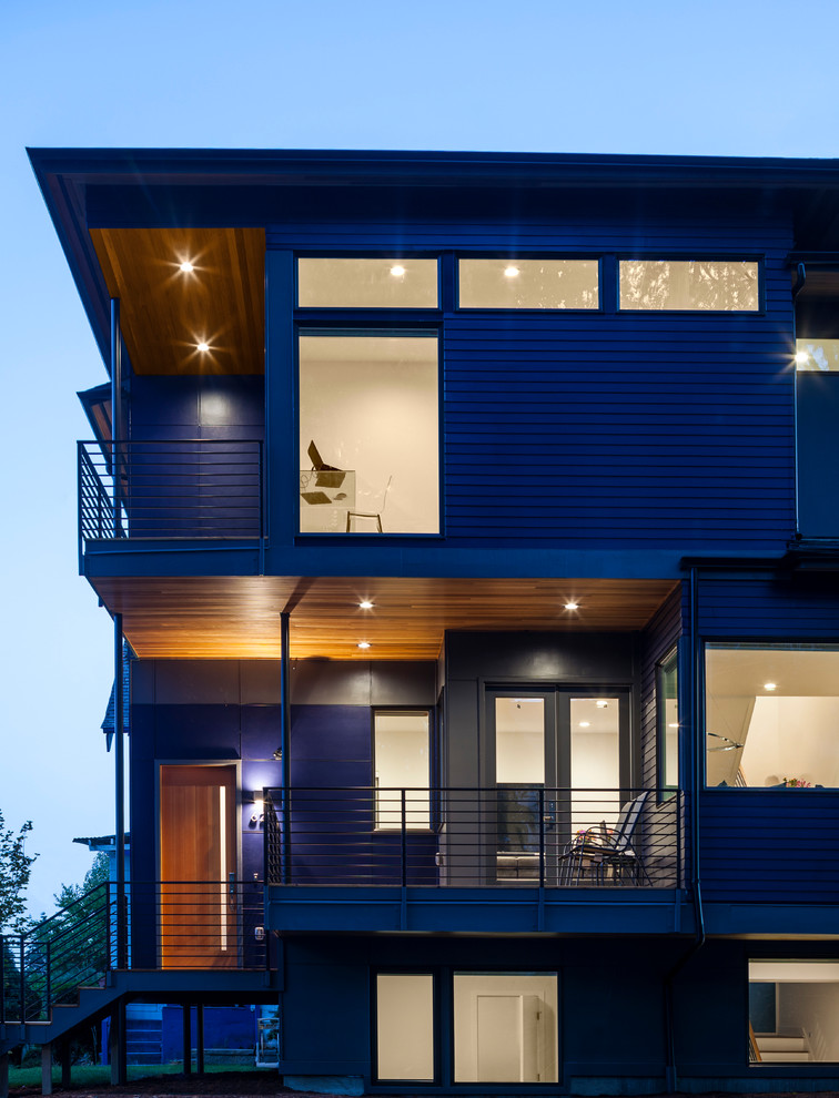 Exempel på ett mellanstort modernt blått hus, med tre eller fler plan, fiberplattor i betong och valmat tak