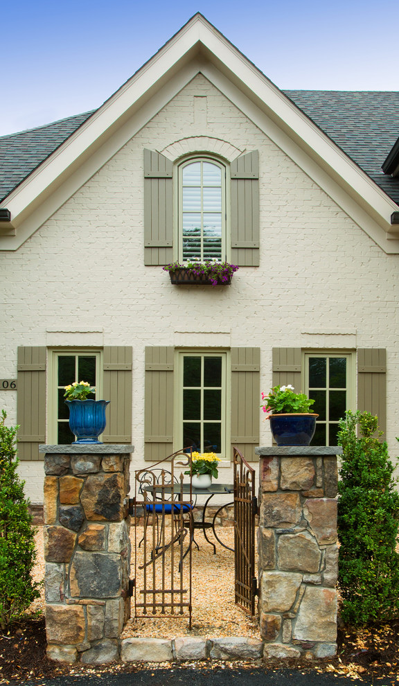 Foto della facciata di una casa beige classica a due piani con rivestimento in mattoni