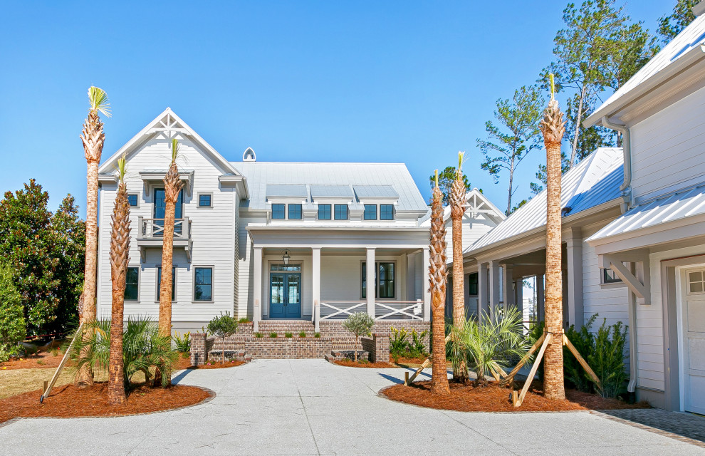 Esempio della villa grande beige stile marinaro a due piani con rivestimento con lastre in cemento, tetto a capanna e copertura in metallo o lamiera