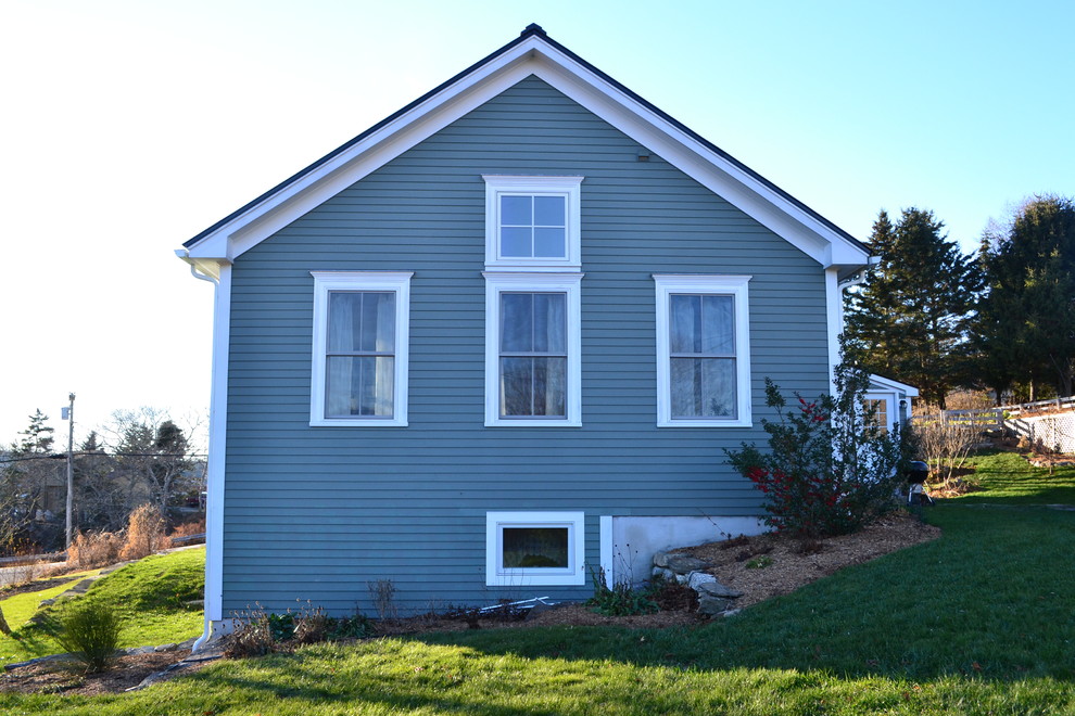 Idées déco pour une grande façade de maison bleue classique en bois à niveaux décalés.