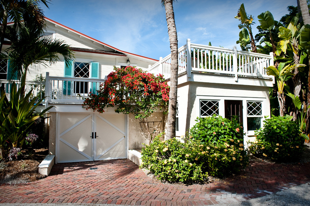 Example of a mid-sized beach style white two-story wood exterior home design in Miami with a metal roof