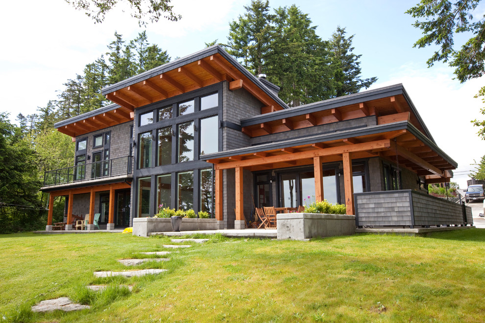 Cette photo montre une façade de maison grise tendance en bois avec un toit en appentis.