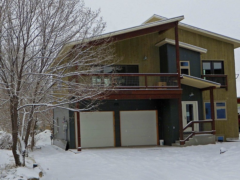 Foto della facciata di una casa piccola grigia industriale a tre piani con rivestimento in legno e abbinamento di colori