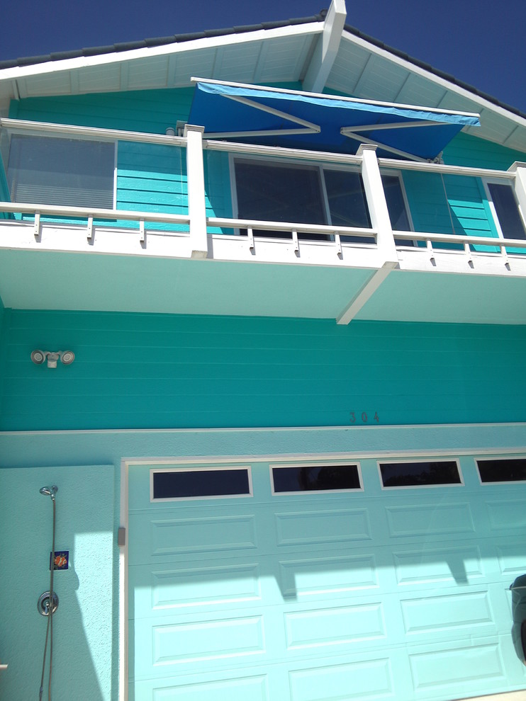 Large and blue beach style two floor house exterior in San Diego with wood cladding.