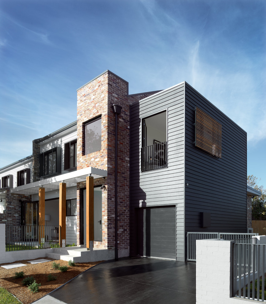 Diseño de fachada de casa bifamiliar gris contemporánea grande de dos plantas con revestimiento de ladrillo, tejado a dos aguas y tejado de metal