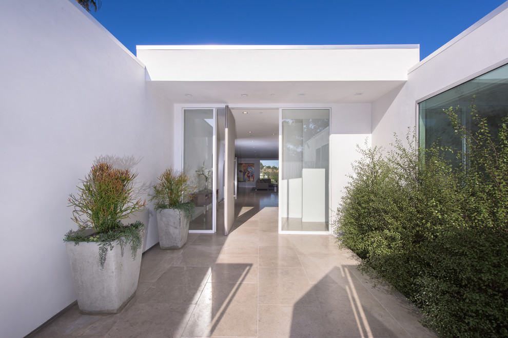 Mid-century modern white one-story stucco exterior home photo in Los Angeles
