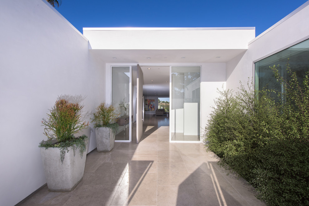 Immagine della villa bianca moderna a un piano con rivestimento in stucco e tetto piano