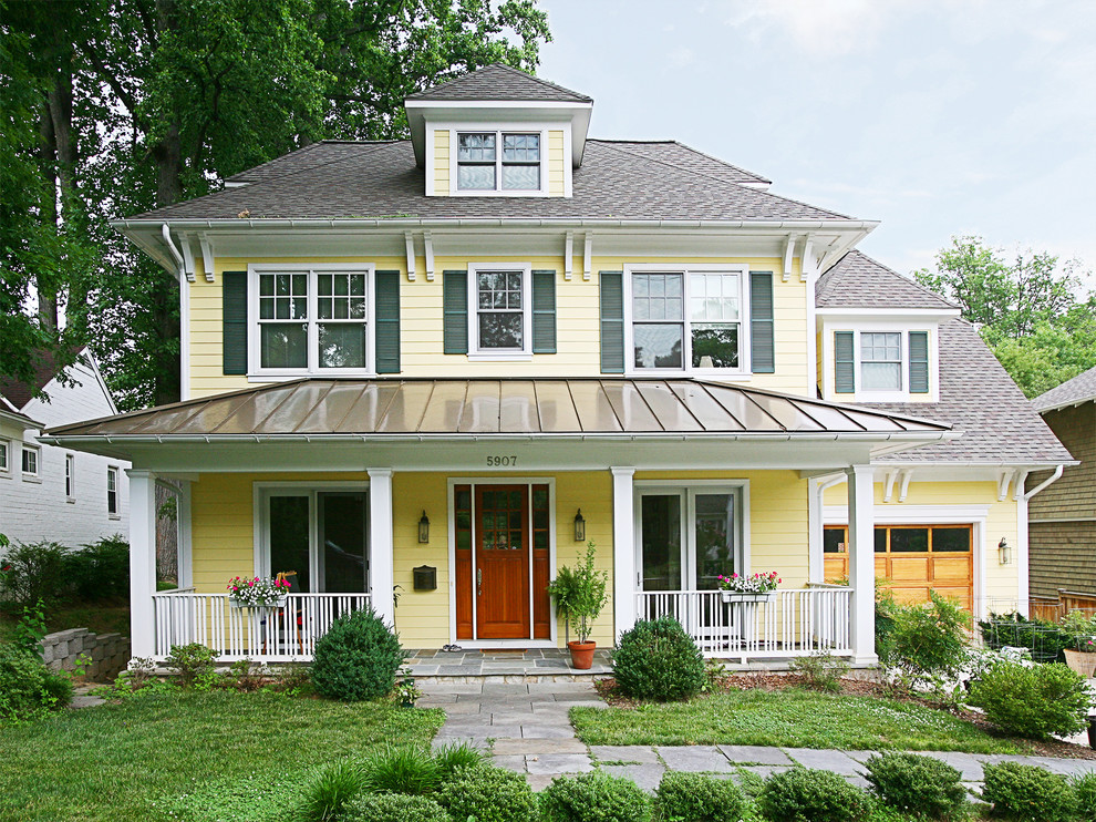 Foto della facciata di una casa gialla american style a due piani di medie dimensioni con rivestimento in legno e tetto a padiglione